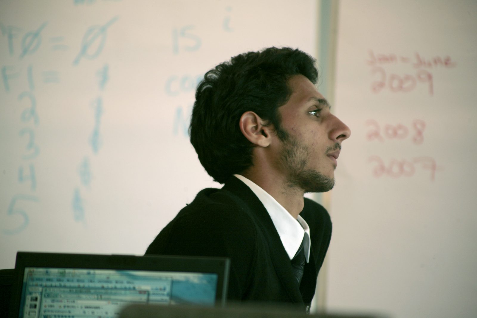 A resident working through figures at the whiteboard